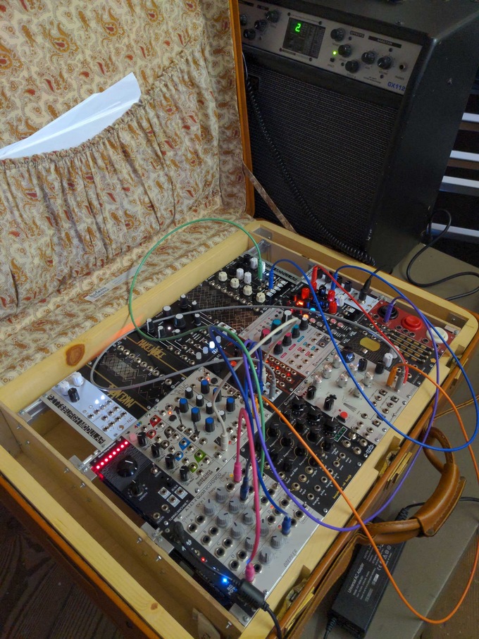 patched eurorack suitcase synth with amplifier